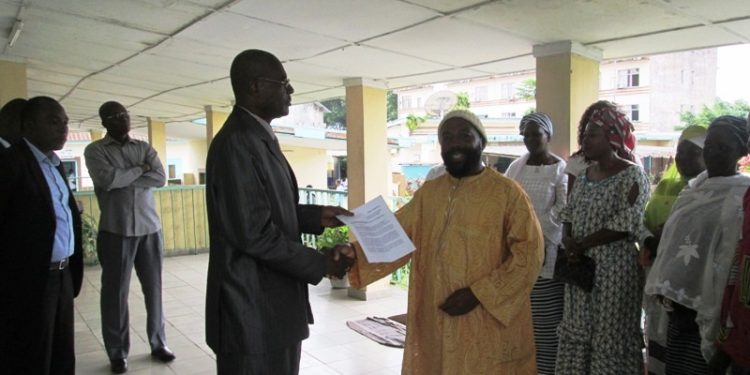 Le Ministre-Conseiller de l&rsquo;ambassade recevant la motion de protestation des Sans Voix